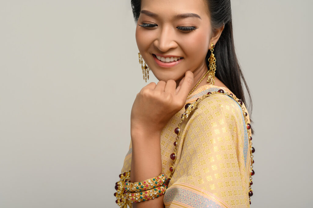 Asian female jewelry model wearing yellow gold jewelry set