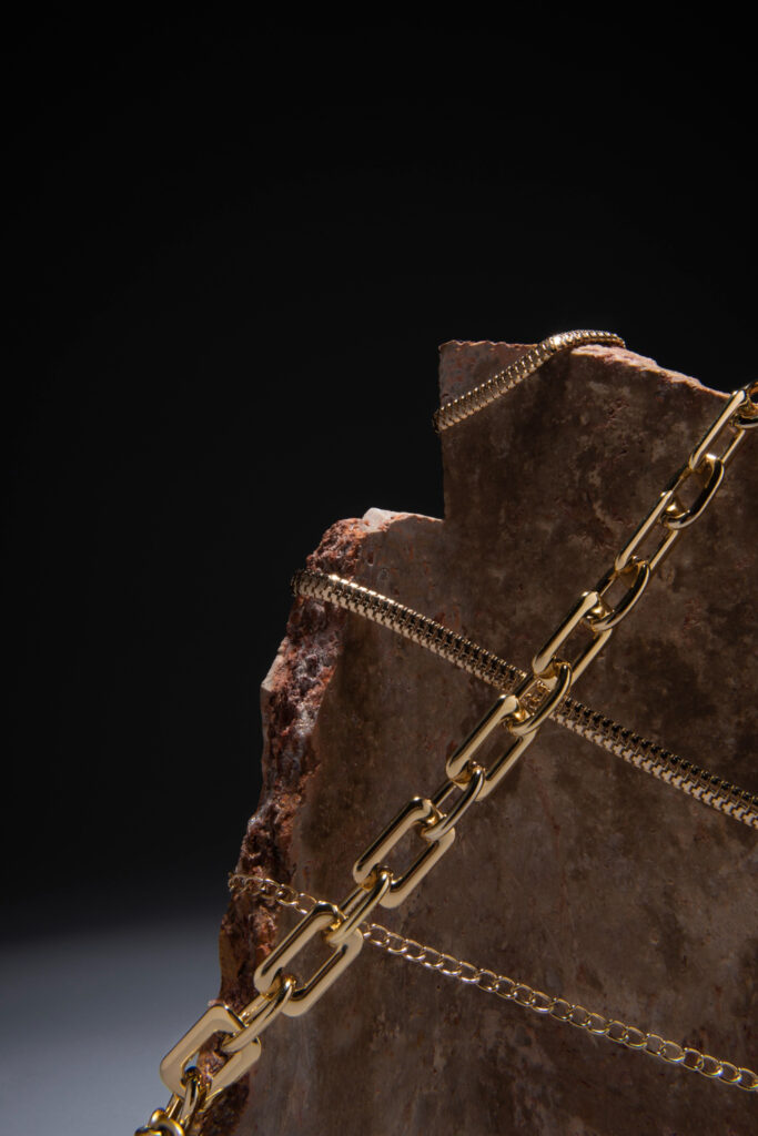 Yellow gold chains wrapped around a prop rock stone