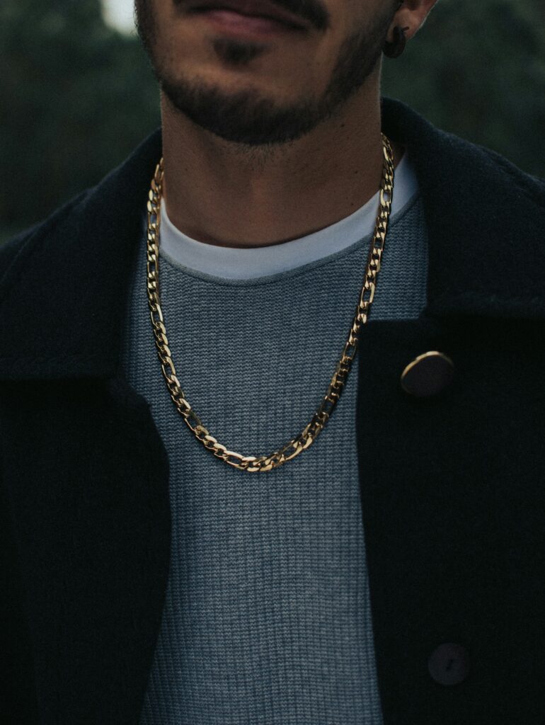 Yellow gold chain links worn by a male jewelry model