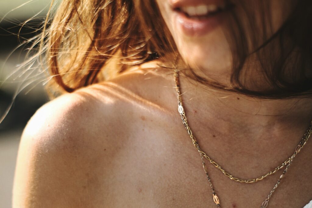 Pale skin female jewelry model wearing gold necklace